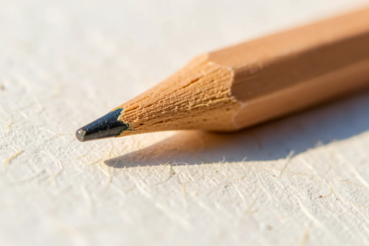 Lyijykynän kärki paperin pinnalla lähikuvassa.